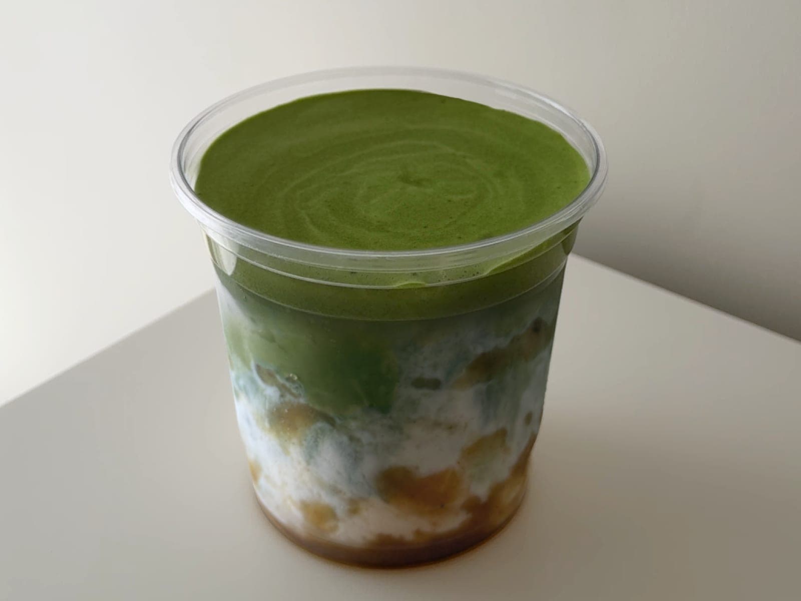 Iced matcha poured over banana pudding